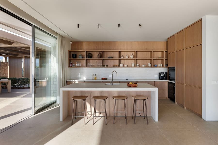 Oak kitchen designed around a stone island and open shelving
