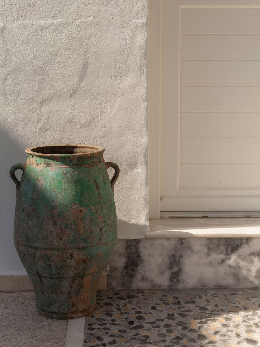 Weathered green patina vessel highlighting the material palette of the restored Cycladic architecture at YAPA Antiparos