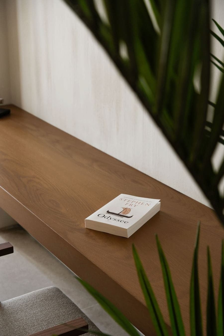 Floating timber desk styled with books and natural materials in the villa bedroom