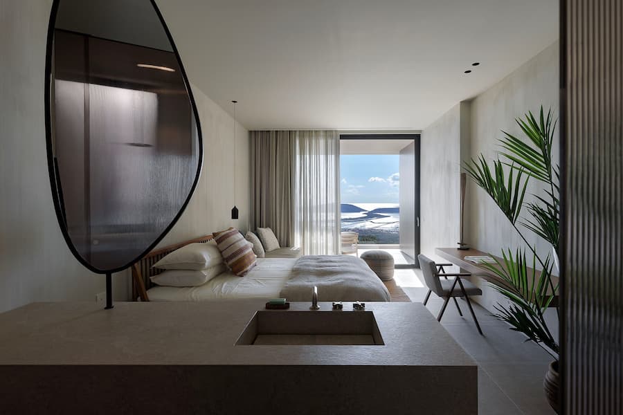 Bedroom suite with integrated bathroom overlooking Navarino Bay through expansive glazing