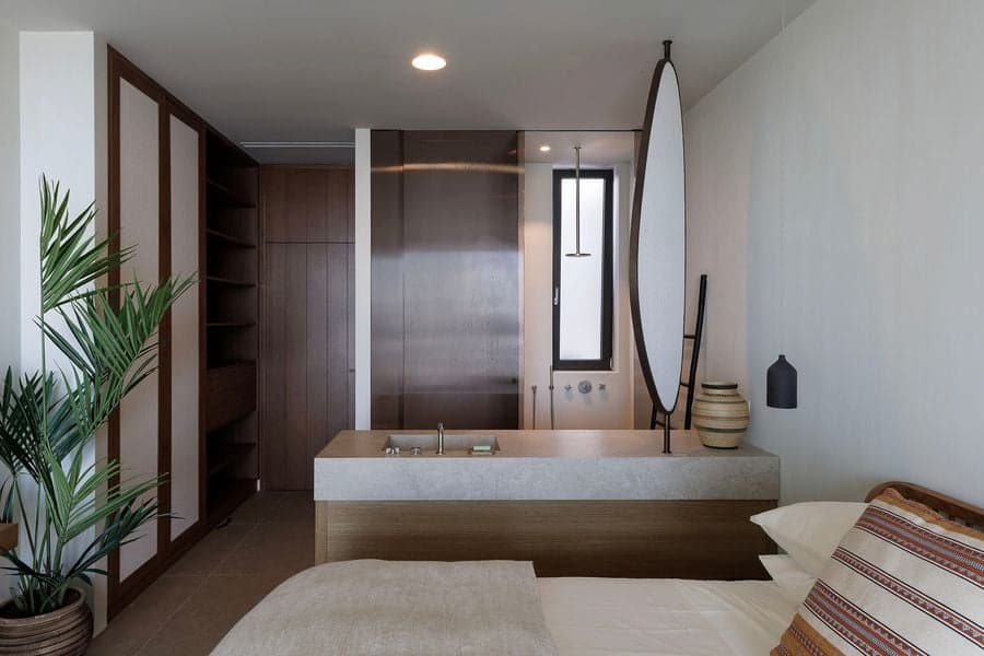 Integrated bathroom and bedroom featuring custom timber joinery and minimalist detailing