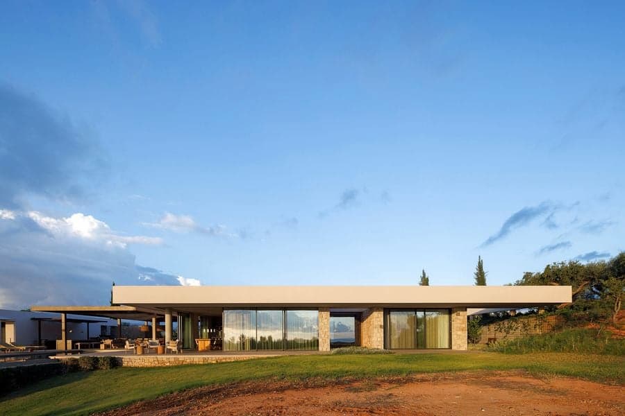 Cantilevered bedroom wing framed by a minimalist white façade and sunset light
