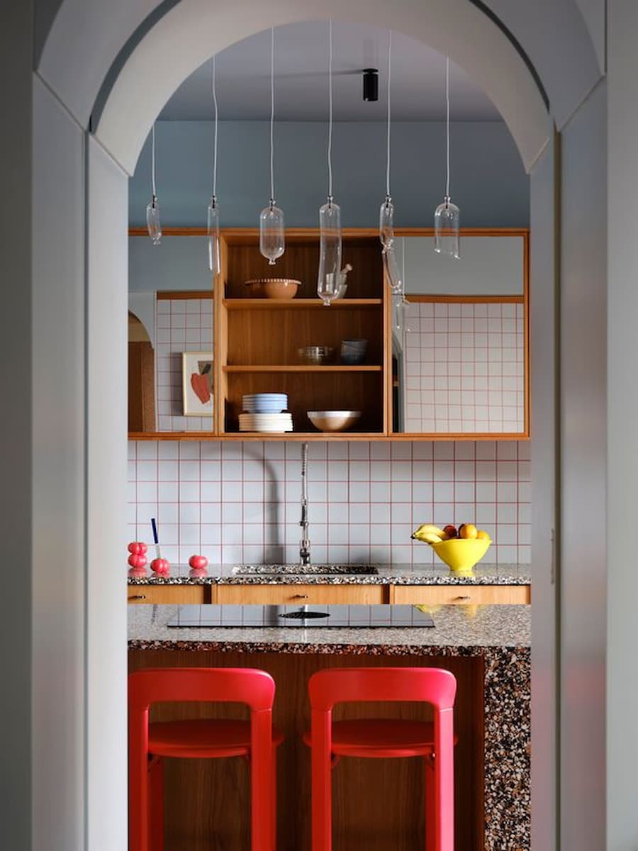 Studio Plutarco founders standing behind the translucent red vinyl entrance of the renovated Madrid villa.