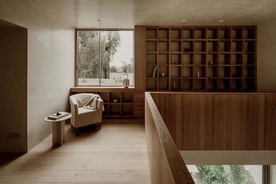 Built-in timber library overlooking the double-height living space below