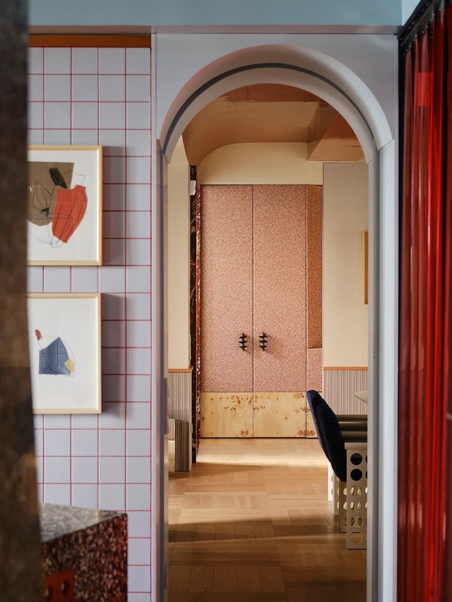 Arched opening connects the kitchen and living spaces through carefully composed color, light and geometry.