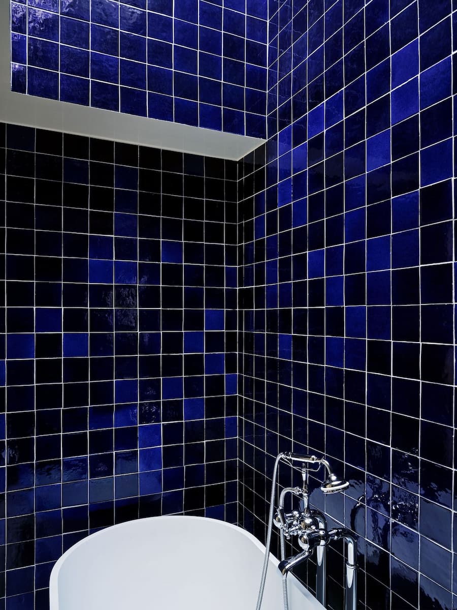 Deep cobalt blue ceramic tiles create a dramatic bathroom at Bus Palladium Hotel Paris