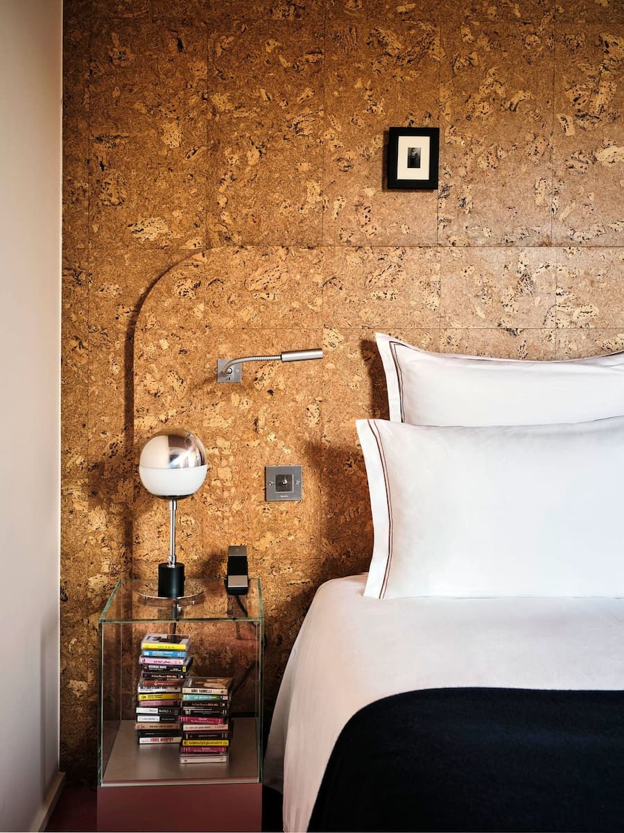 Bedroom corner finished with natural cork walls and vintage lighting by Studio KO
