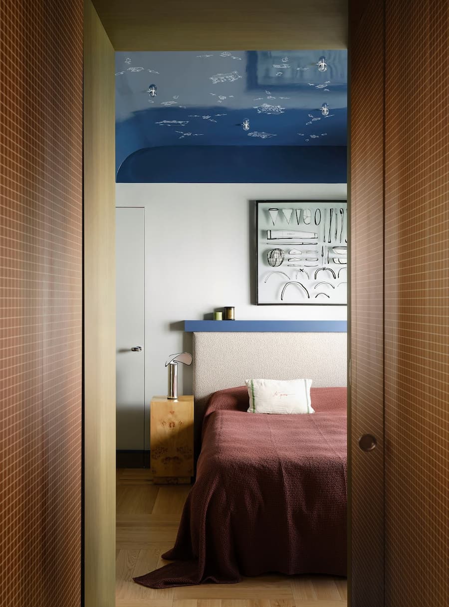 Bedroom with deep blue ceiling, custom furnishings and handcrafted details inside the renovated Madrid home.