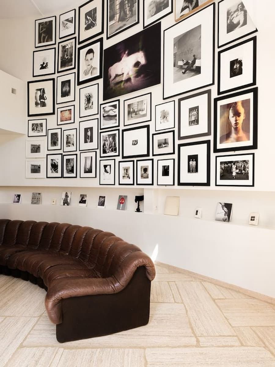 Double-height photography gallery at Casa Ideale featuring works from Carla Sozzani's private collection