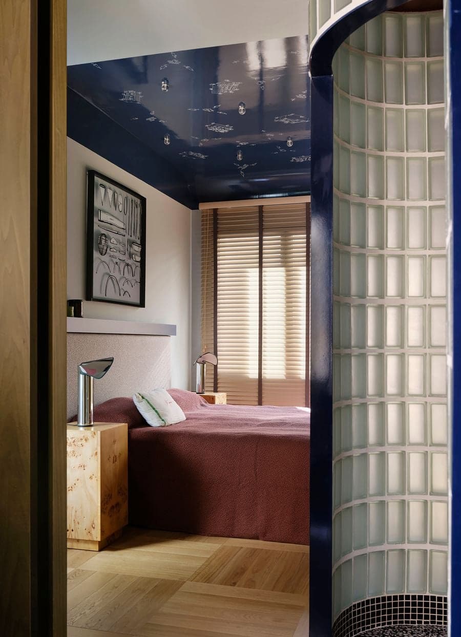 Curved glass block wall connects the bedroom suite with soft light and expressive architectural forms.