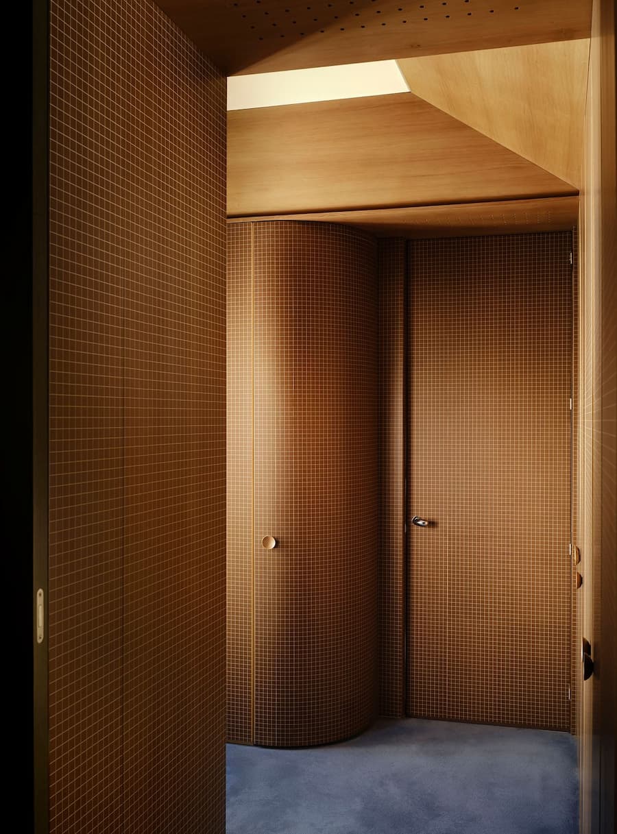 Curved mosaic-tiled corridor creates a seamless transition between the private rooms of the residence.