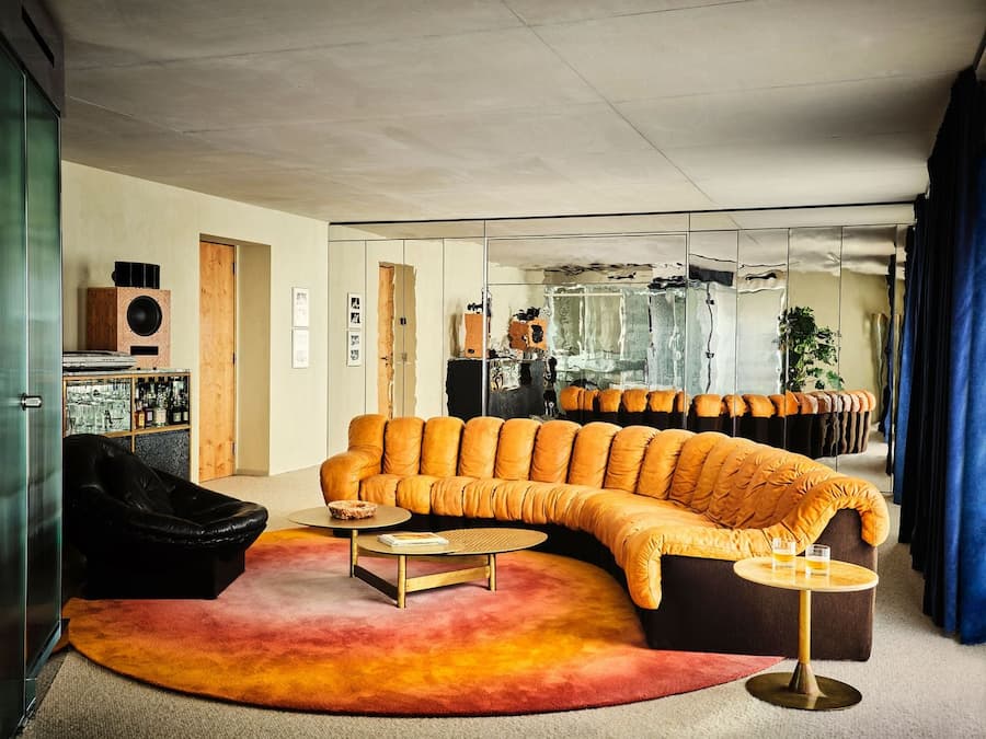 Curved leather sofa anchors an open-plan suite designed by Studio KO