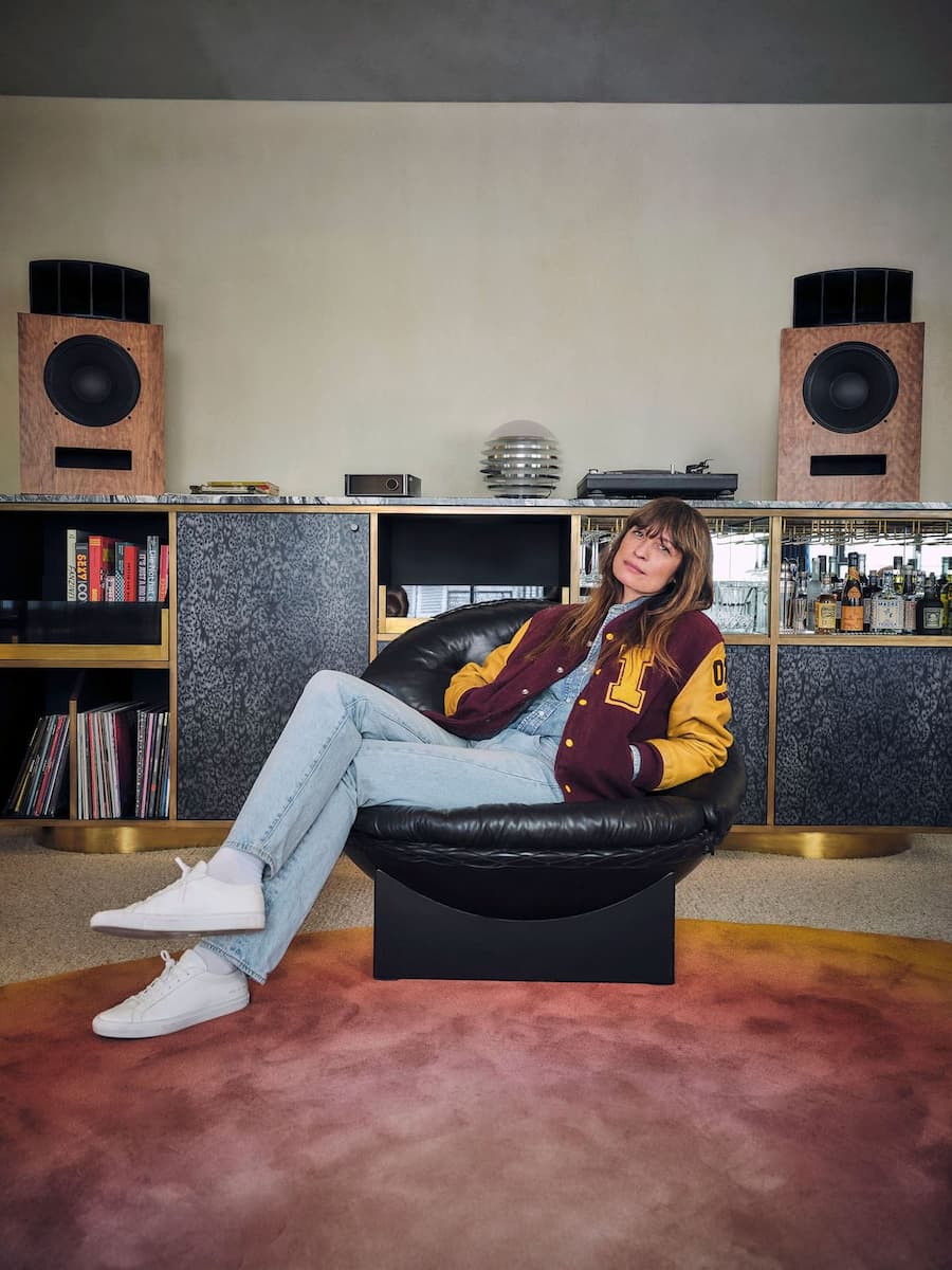 Creative director seated in the hotel lounge surrounded by custom audio furniture