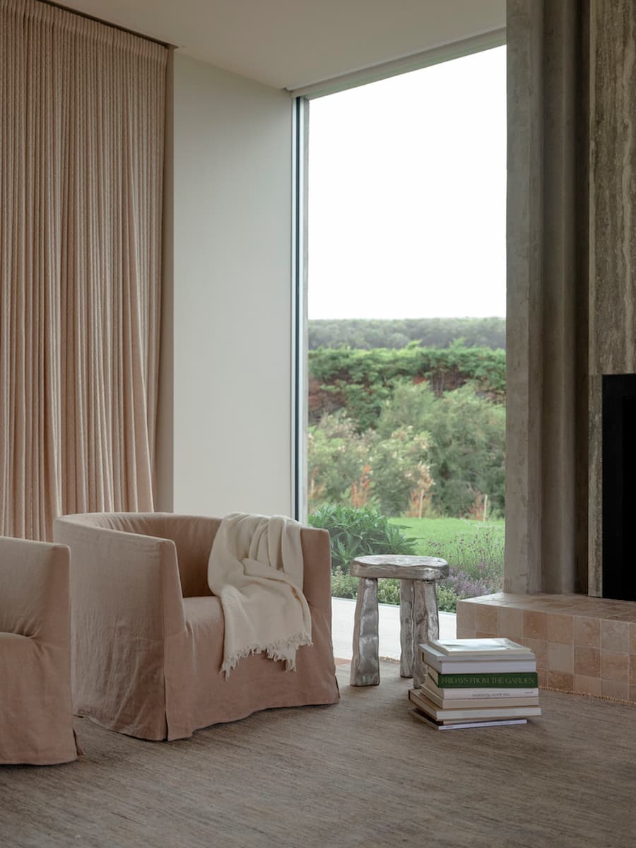 Living room framed by floor-to-ceiling glazing overlooking the coastal garden at Wildcoast Residence.