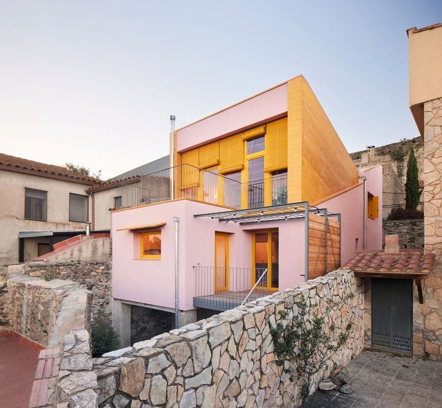 Exterior view showing the renovated village house integrated into the historic streetscape of Rabós.