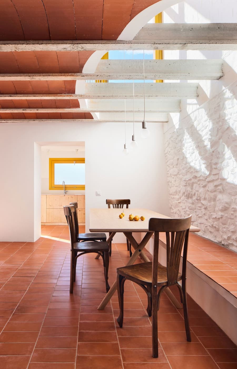 Dining area illuminated by the roof lightwell beneath the original Catalan vaulted ceiling at Ca la Carolina.