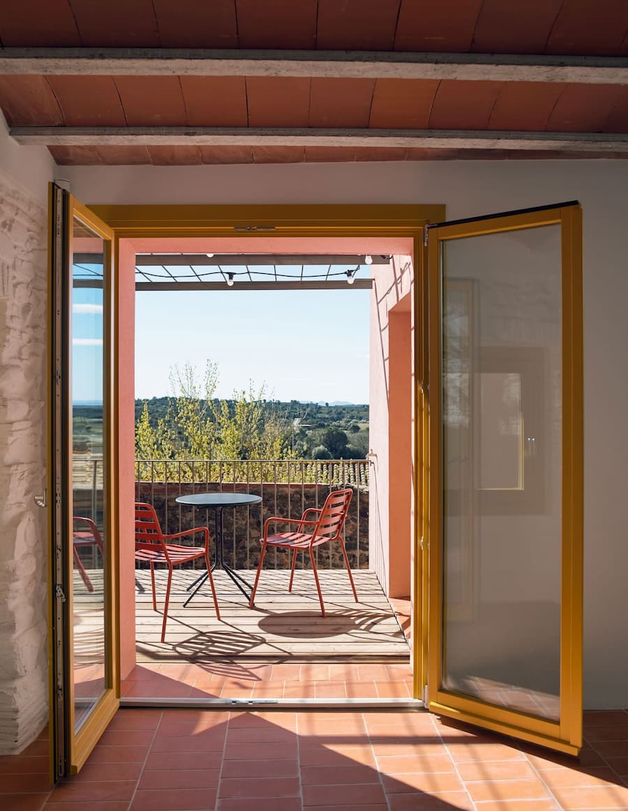 Open terrace doors connecting the living space with the countryside view at Ca la Carolina.