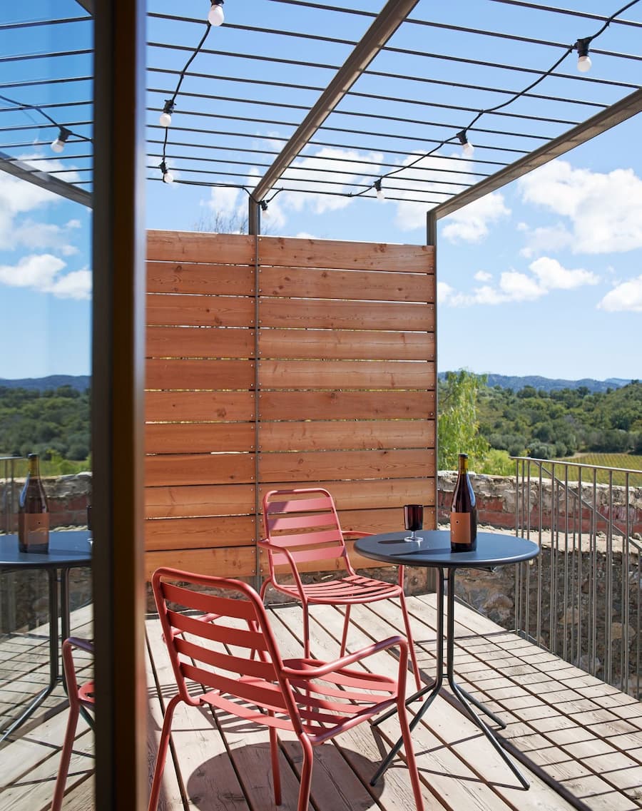 Timber terrace with outdoor seating overlooking the surrounding landscape at Ca la Carolina.