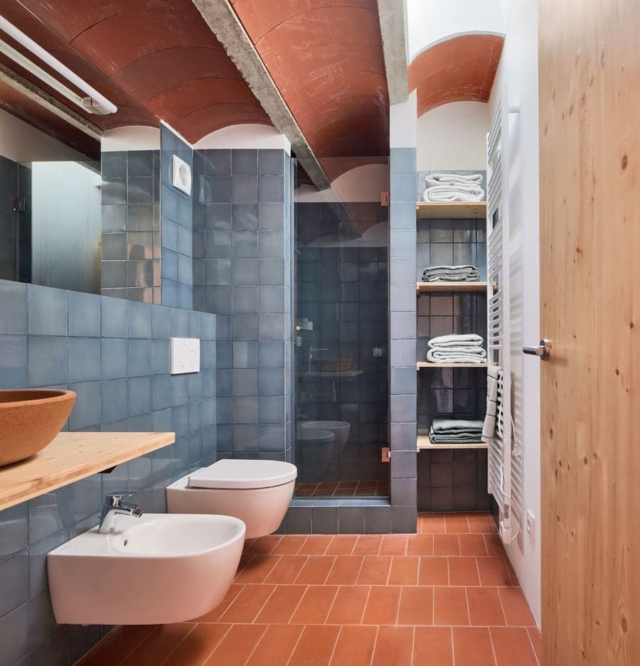 Blue tiled bathroom beneath the original Catalan vaulted ceiling at Ca la Carolina.