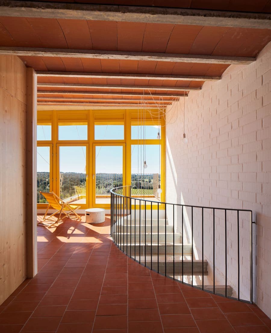 Stair hall connecting interior spaces with panoramic countryside views at Ca la Carolina.