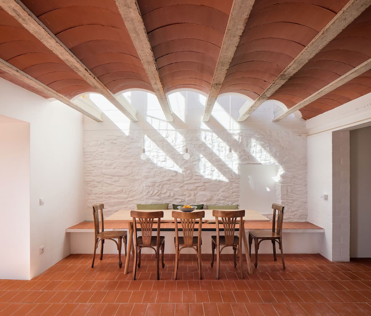 Dining space beneath a Catalan vaulted ceiling at Ca la Carolina renovated by Lacol and Altura Arquitectes.