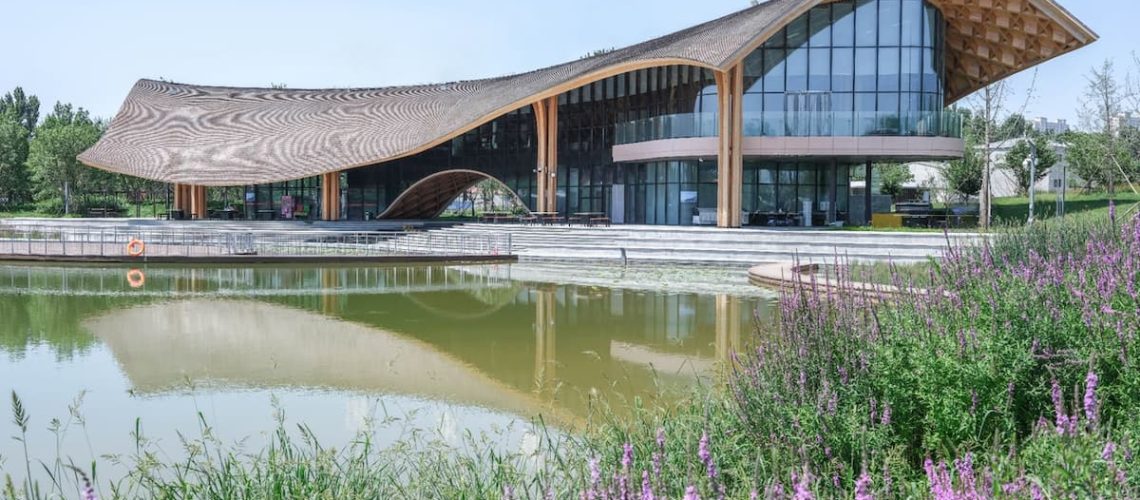 landmark timber architecture with flowing roof integrated into lakes landscape