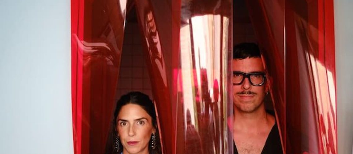 Studio Plutarco founders standing behind the custom translucent red vinyl entrance in the renovated Madrid villa.