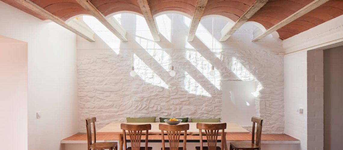 Dining space beneath a Catalan vaulted ceiling at Ca la Carolina renovated by Lacol and Altura Arquitectes.